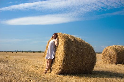 woman on a haystack in a field outside the city
