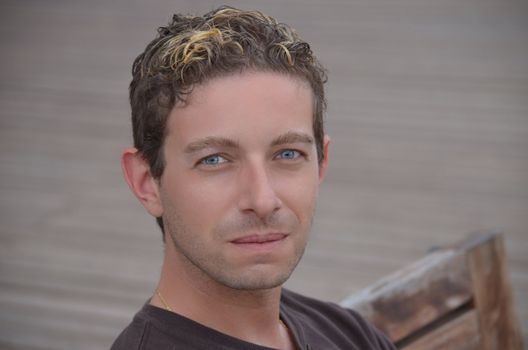 Good looking blue eyed guy sitting on bench