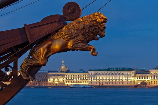 View of the Palace Embankment. In the foreground, a decorative sculpture of a lion on the bow of sailing ship. Twilight, white night. St. Petersburg. Russia