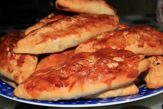 Roasted homemade pies stuffed with cabbage on a plate