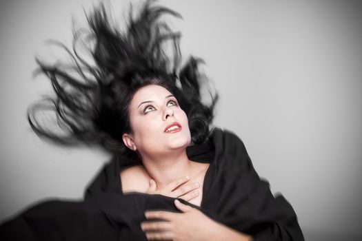 Beautiful woman in studio shot with wind on hair .