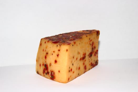 Piece of cheese with red bell pepper and spices