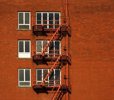 Red brick building with three rows of windowed fire escapes