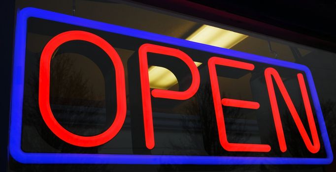 Red and blue neon open sign at store with background interior lights