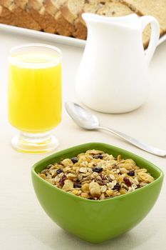 delicious breakfast with orange juice, whole grain bread,milk and a healthy bowl of cereal.