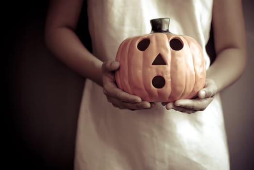 a child holds the pumpkin