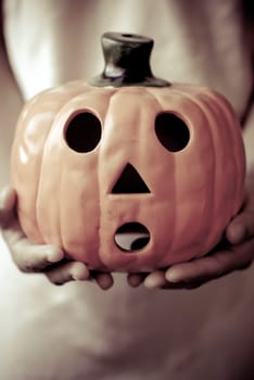 a child holds the pumpkin