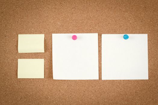 four empty note papers on cork board
