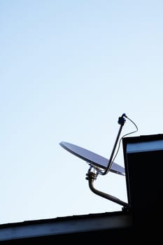 Satellite dish Antenna mounted on the roof with blue sky in the morning time