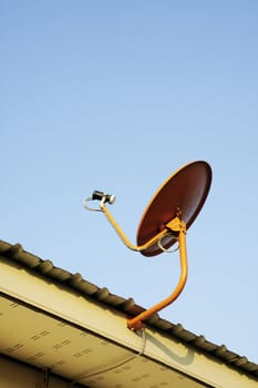 Satellite dish mounted on the roof with blue sky 