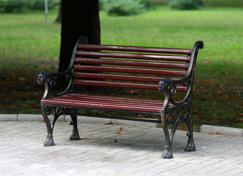 Metal forged bench in autumn park with lions