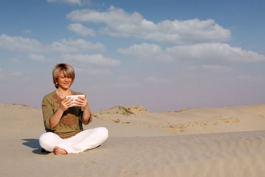 beautiful woman with tablet pc in desert