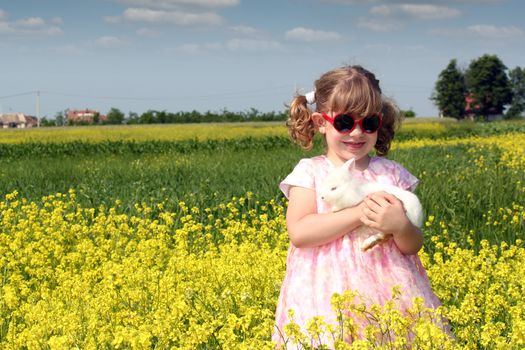 little girl with dwarf white bunny spring scene