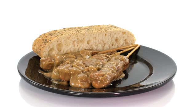 asian dish with bread and sate on white background