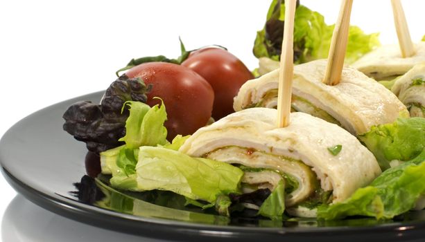 dish with salmon wraps salad and tomatoes