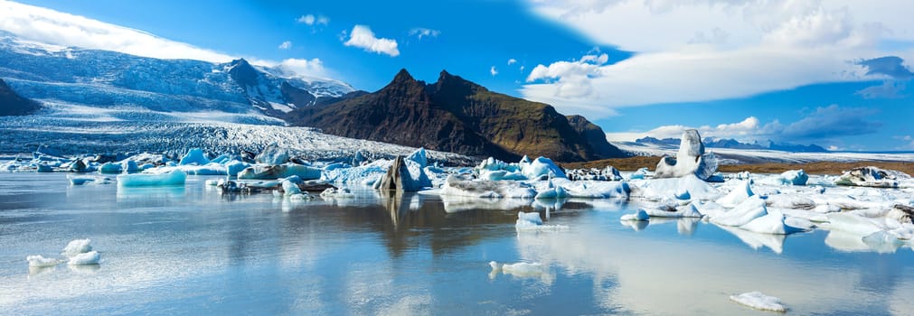 Beautiful panoramic photo of Fjallsarlon Glacial lake full of floating icebergs near the Fjallsjokull glacier