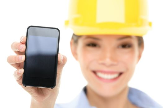 Engineer woman showing smart phone wearing construction hard hat. Young female mixed race Asian / Caucasian female professional isolated on white background.