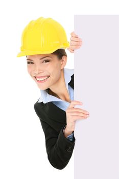 Engineer entrepreneur architect business woman showing blank white sign for copy space. Young multiracial Caucasian / Asian Chinese young professional wearing suit and hard hat.