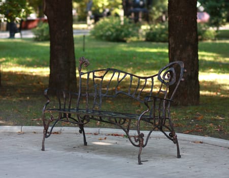 Metal abstract forged bench in summer park