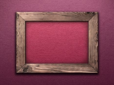 Old wooden frame empty inside on purple wall