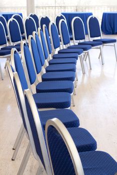 Curved row of empty conference chairs