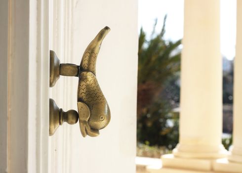 Fish shaped Maltese door knocker on a palazzo door