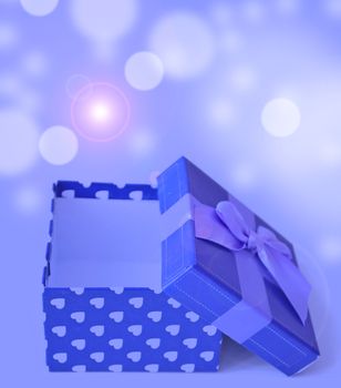 blue jewellery box with ribbon in bukeh background