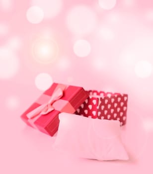 red gift box with hearts and small pillow for your ring on bukeh background