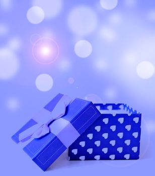 blue jewellery box with ribbon in bukeh background