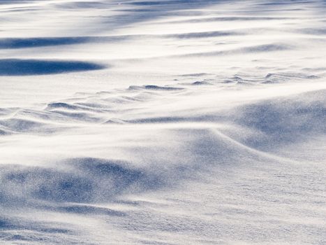 Blizzard background texture pattern: drifting snow crystals driven by strong wind creating snow surface refief
