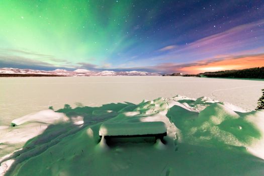 Spectacular display of intense Northern Lights or Aurora borealis or polar lights forming green swirls over frozen Lake Laberge  Yukon Territory  Canada winter landscape