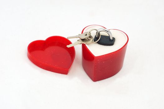 A marriage ring is replaced by a little lock and 2 keys in a heart shaped proposal box
