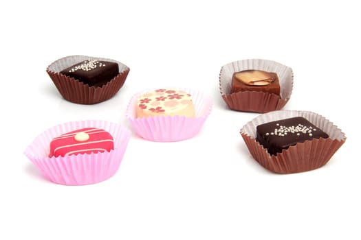 five delicious pink petit four over white background