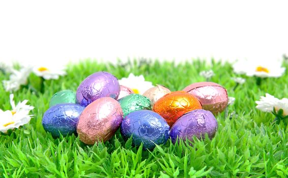 colorful easter eggs in plastic grass over white background