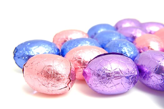 colorful chocolate easter eggs over white background