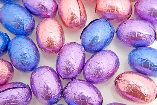 colorful chocolate easter eggs in closeup over white background