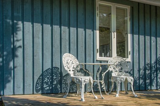 Veranda with desk and chairs in front of a danish summer residence