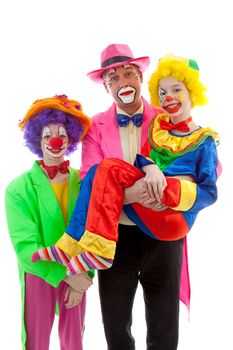 Three people dressed up as colorful funny clowns over white background