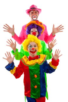 Three people dressed up as colorful funny clowns over white background