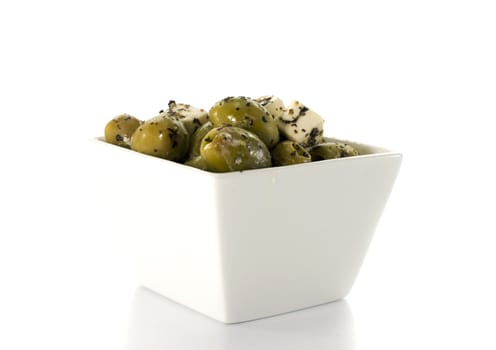 fetta cheese and green olives on white background
