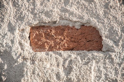 Brick hidden under shabby plastering