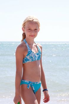 Girl at the beach in bikini looking into camera
