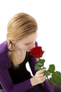 young girl smelling a red rose in closeup over white background