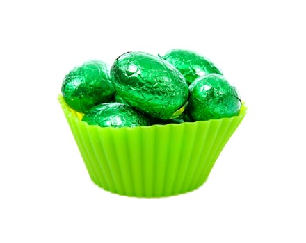 green bowl with easter eggs over white background