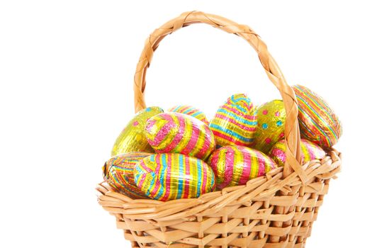 Cane basket with colorful easter eggs over white background