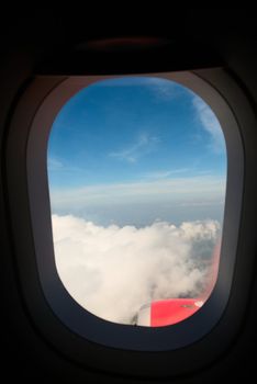 Cloudy blue sky through open airplane window