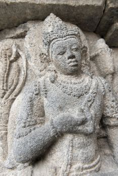 Stone carving with men (9th century) on Shiva temple top in Candi Prambanan or Candi Rara Jonggrang Hindu temple, Java, Indonesia