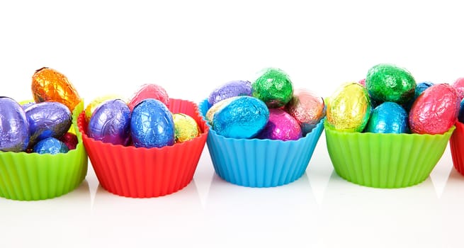 colorful bowls with easter eggs over white background