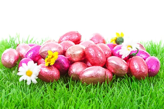 Pink easter eggs on grass over white background