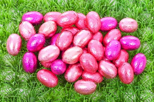 Pink easter eggs on grass in closeup
